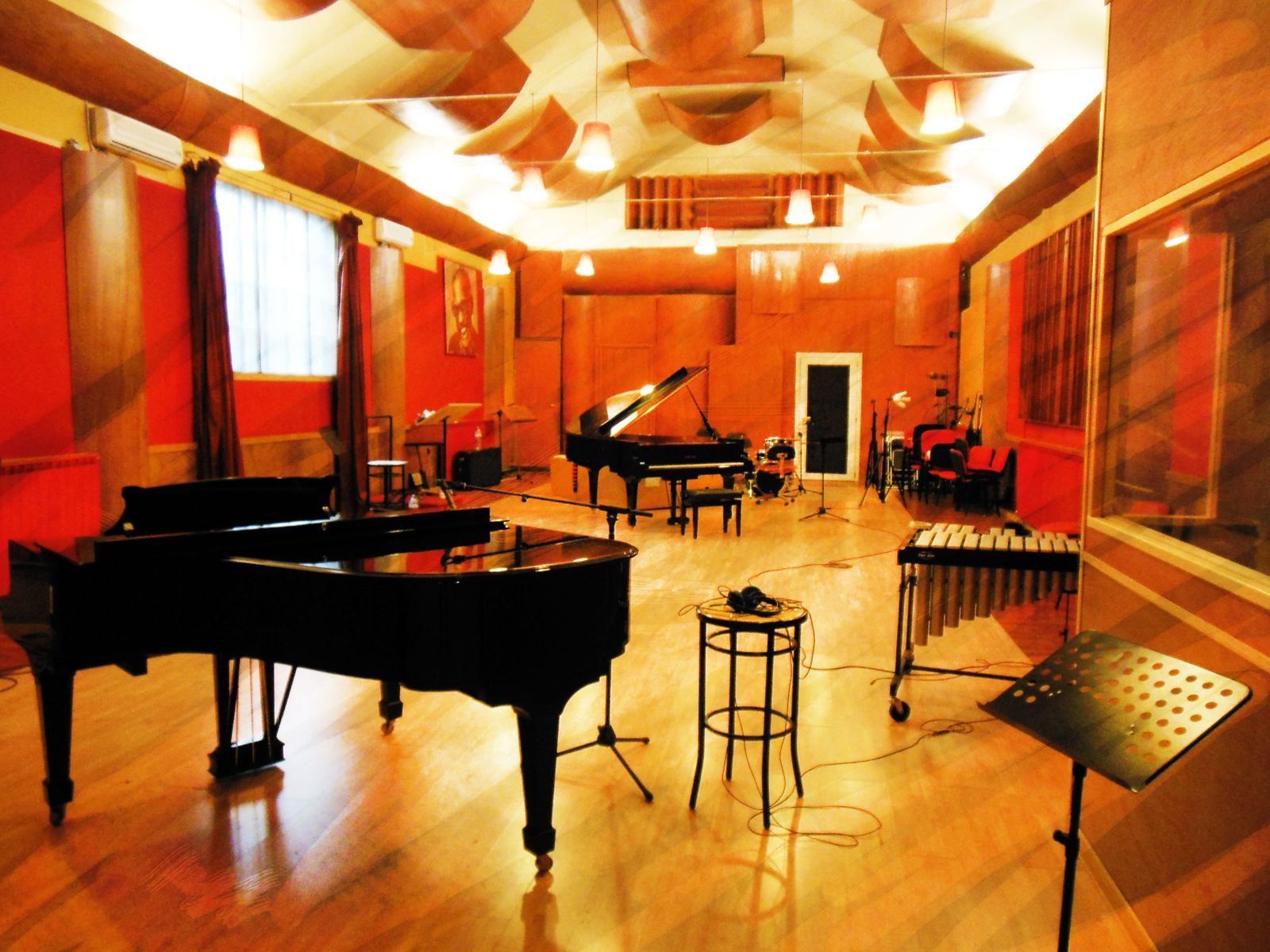 La grande sala di ripresa del New Art Recording Studio, con due pianoforti a coda, un vibrafono, una batteria e le pareti rosse e in legno