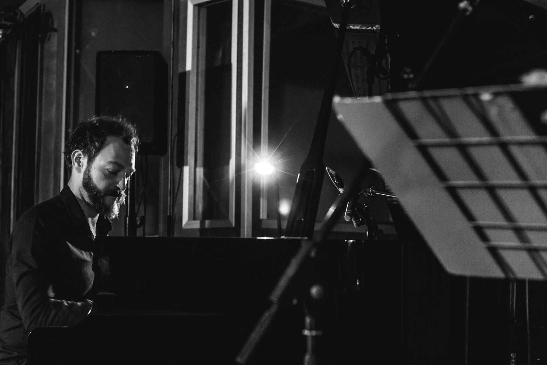 Paolo Censi al pianoforte a coda in studio, in bianco e nero, dietro un leggio